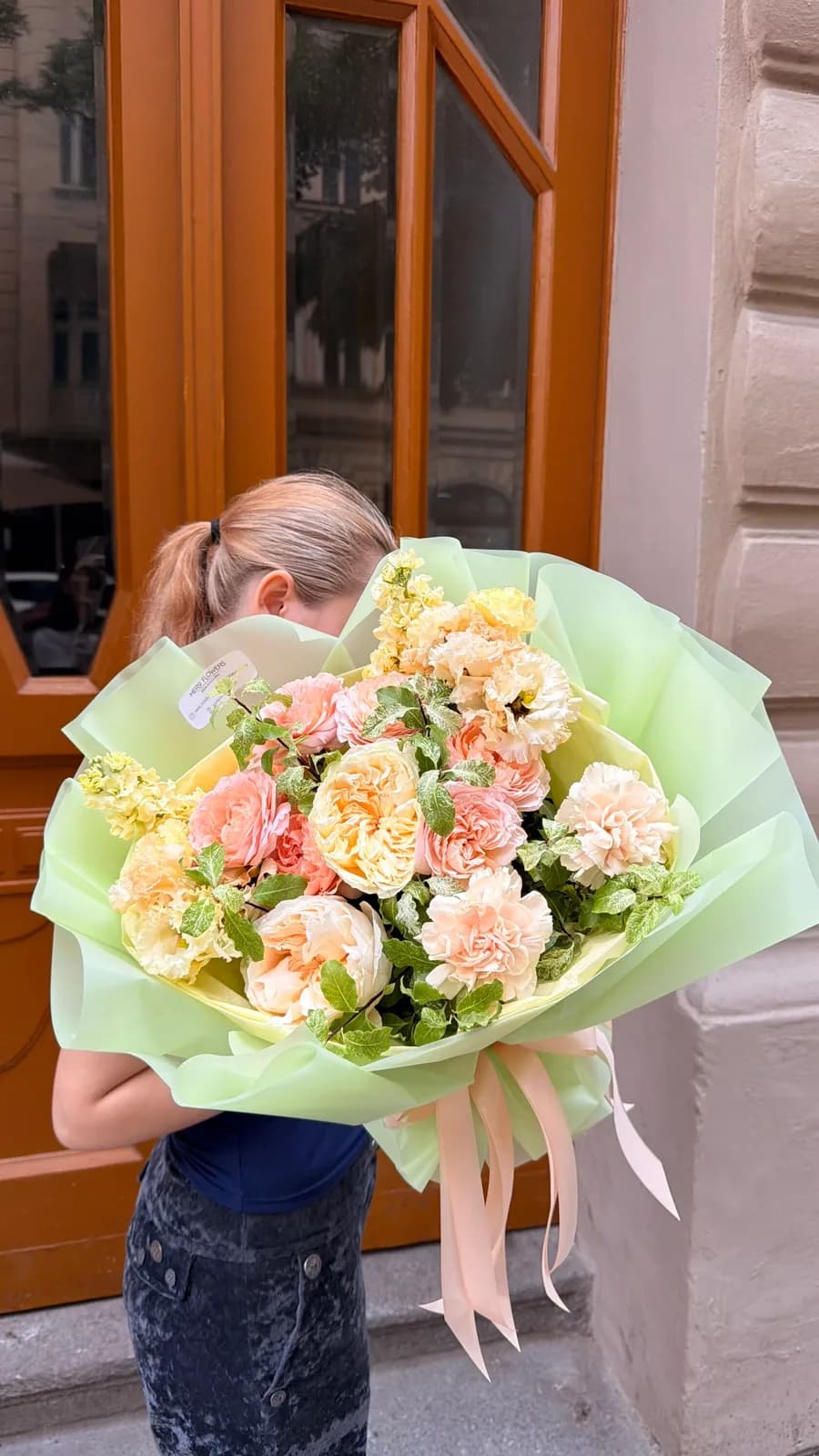 Pistachio bouquet of cream and peach roses, lisianthus and stock with greenery